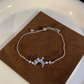 Elegant adjustable silver bracelet with blue moon pendant and sparkling star accents - Blue Moon