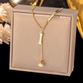 Close-up of golden letter I pendant with geometric cube on a dainty Y-shaped chain - Letter I-Gold