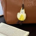 Handmade wool felt banana keychain with smiley face embroidery on a leather bag - Friendship Banana