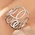 Close-up of bohemian hollow geometric silver stainless steel ring on gold satin fabric - Silver Hollow Cage (C1490)