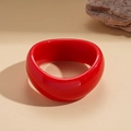 Detail van een brede chunky felrode acryl armband met glanzende spiegelafwerking en glad oppervlak - Rode Gedraaide Stijl