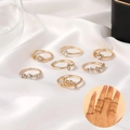 Set di 8 anelli dorati con stelle e lune e cristalli trasparenti su raso bianco - Set Di Anelli Impilabili Oro Con Strass Delicati (9840)