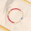 Handgefertigtes Perlenarmband mit Augen-Anhänger auf einem eleganten Marmorteller - 4# Rotes Armband