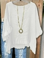 Dettaglio di un top bianco con scollo a V, orlo a balze e collana vintage su gruccia - S / Bianco