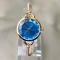 Elegant gold bracelet watch with a blue faceted dial and sparkling rhinestone accents - Blue