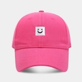 Détail d'une casquette rose en coton avec écusson carré brodé d'un visage souriant - Rose Clair