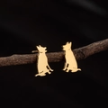 Polished gold German Shepherd silhouette stud earrings on a natural wood branch - Sitting German Shepherd (779) / Steel