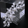 Detail of silver bridal hair comb with pearls and rhinestones on a dark reflective surface - Style 81259