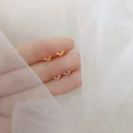 Minimalist 925 silver leaf stud earrings in gold and silver finish shown on fingers - Small Sprout / Gold
