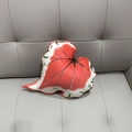 Detailed view of leaf-shaped plush pillow with realistic Caladium vein texture on a grey sofa - Rex Begonia