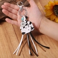 Western boho keychain with cow print cowhide, turquoise beads, and long suede tassels - Cow Print