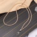 Details einer funkelnden goldenen Umhänge-Handykette mit Metall-Karabinerverschluss - Crossbody-Stil / Champagner