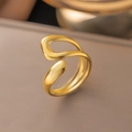 Primo piano di un anello dorato minimalista regolabile con finitura in metallo lucido - Anello Cavo Irregolare / Oro