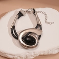 Dettaglio del pendente ovale geometrico con cornice argentata e resina nera su pietra - Bracciale / Argento