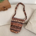 Detail of floral knit hobo bag in orange and brown tones on a cozy white sofa - Orange Blue Stripes