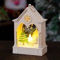 Close-up of white house-shaped LED Christmas lantern with warm glow on wooden surface - Beige Christmas Tree