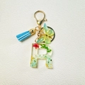 Letter R resin keychain with green dried flowers, gold foil, and blue tassel charm - Letter R
