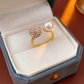 Dettaglio di un anello aperto vintage con perla e cristalli in una scatola regalo - Oro