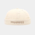 Dettaglio del cappello docker crema con ricamo PROGRESS e design vintage consumato - Regolabile / Beige