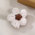 Macro shot of handcrafted white knitted flower with brown center for brooch DIY - Beige
