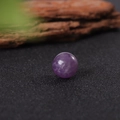 Polished 16mm purple natural amethyst crystal sphere on a black textured background - Purple Crystal