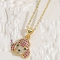 Dettaglio macro di un ciondolo a forma di cucciolo dorato con zirconi rosa e bianchi brillanti - Zirconia Rosso Rosa (Oro)