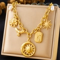 Detailed shot of vintage gold sun, moon, and bird pendants on a stainless steel necklace - Sun Moon Dove Starfish (N3170)