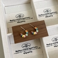 Gros plan sur les boucles d'oreilles en C en émail arc-en-ciel avec base en métal doré - Arc-en-ciel Or 16K