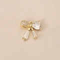 Macro shot of 18K gold bow pendant featuring heart-shaped zircon on textured fabric - Combination Zirconia Bow (PJ0245) / Gold