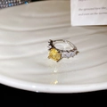 Macro-opname van een zilveren ring met gele edelsteen met geel en baguette zijdiamanten - Gele Ronde Zirkonia Stijl
