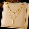 Golden double-layered stainless steel necklace with leaf and teardrop pendants on beige box - Gold Leaf & Bar Pendant Style (N3221)