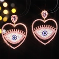 Pink heart-shaped evil eye crystal earrings with gold plating and blue eye center detail - Pink Evil Eye