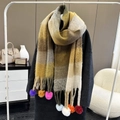 Rainbow plaid scarf in yellow and brown tones with colorful pom-pom tassels on display - Earth Yellow Plaid