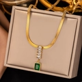 Detail of a gold snake chain necklace featuring an emerald green square pendant in a gift box - Gold