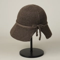 Detailed view of dark brown knitted sun hat with decorative string and bow design - M (56-59cm) / Coffee