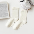 Mid-calf cotton socks in creamy beige color shown on a white table background - One Size / Cream