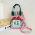 Detail of pink knitted crossbody bag featuring lucky character and woven textures - 33 Phone Bag-Pink Fortune (Fa)