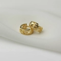 Vue macro de boucles d'oreilles créoles dorées avec texture géométrique tissée - Créoles Ajourées Croisées - Or
