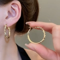Golden minimalist oval hoop earrings with faceted geometric design shown on ear - Gold Geometric Cut Hoop Style (107#)
