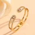 Détail d'un bracelet doré orné d'un zircon poire et de pierres pavées sur fond chaleureux - Style de Pavé de Diamants Goutte d'Eau Double C Or (H321)