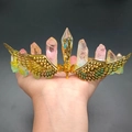 Makro-Detail von goldener Flügel-Tiara mit lebhaften bunten Kristallclustern - Rosagrüner Kristall + Goldene Flügel