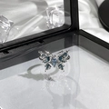 Detail of silver butterfly ring with blue marquise stones on white silk with ice decor - Silver Butterfly Blue Navette Gem Style (6)