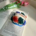 Detailed close-up of knit cosmetic pouch with colorful plush patches and pearl zipper pull - Earphone Case