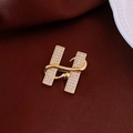 Dettaglio macro della spilla a forma di H placcata oro 18k con cristalli e serpente - Spilla 22# - Oro - Placcato Oro Massiccio