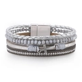 Detail of multi-layer woven bracelet featuring a silver cross charm and magnetic clasp - Silver Gray