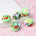Macro shot of colorful glass cartoon beads with floral and insect embossed patterns - Dragonfly