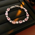 Detail of pink rectangular and white round zircons set in a silver metal bracelet - Pink