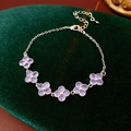 Macro shot of purple cubic zirconia flower bracelet on dark green velvet background - Purple Clover Style (WB1503) / Silver-Purple