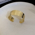 Detailed macro view of wide golden open bangle featuring a wave texture and vertical stripes - Gold Vertical Stripe Dot Style - Small (9#)