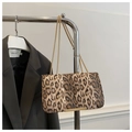 Detail der Handtasche mit Leopardenmuster und goldener Kette vor dunkelgrauem Blazer - Kaffeebraun